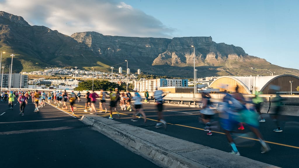 Sanlam Cape Town Marathon runners on Helen Suzman BLVD with Table Mountain as a backdrop