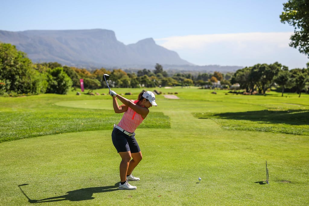 Lady golfer on putting green with view of Table Mountain