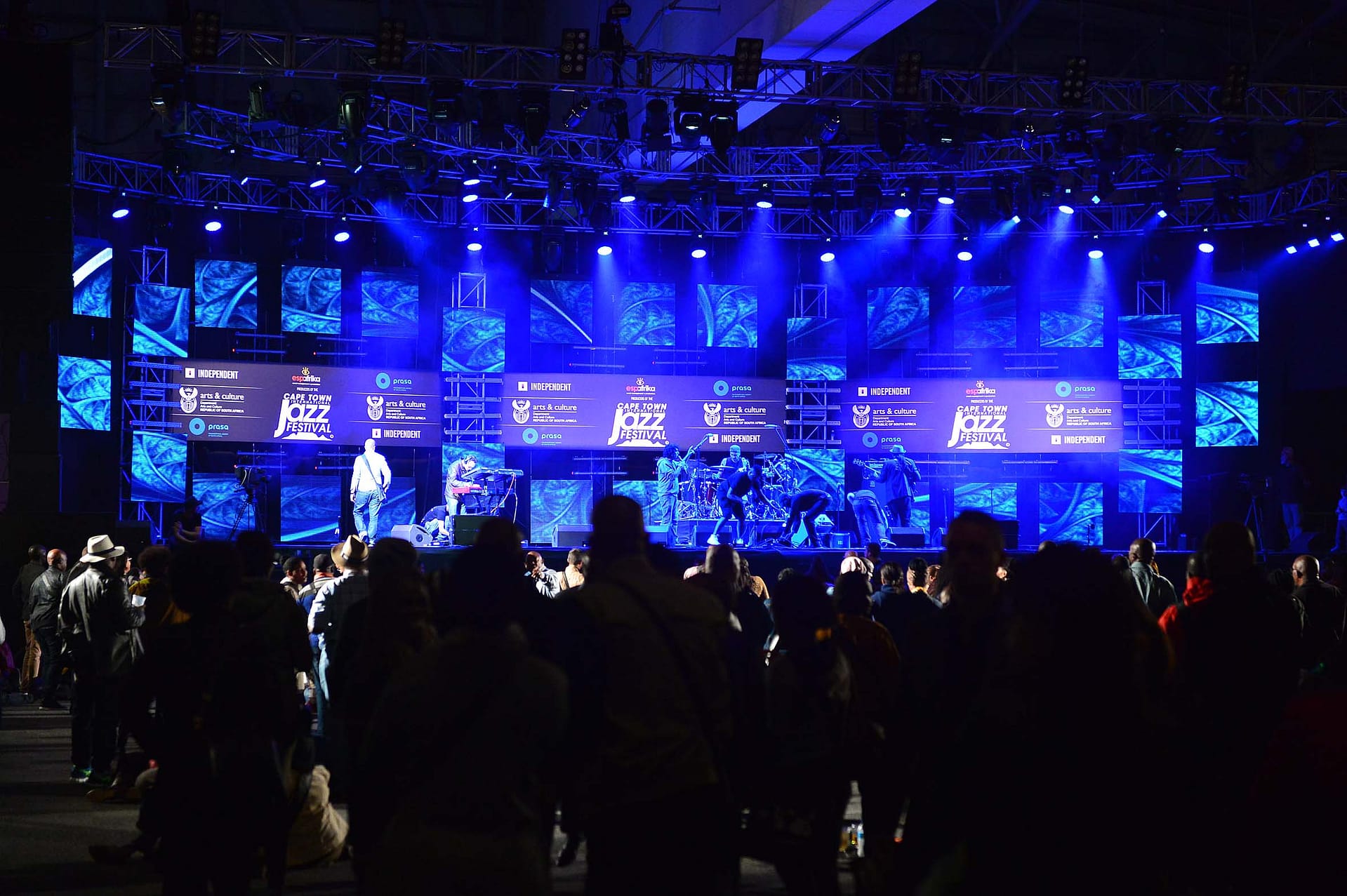 Spectators watching a Cape Town International Jazz Festival Performance on a blue lit stage